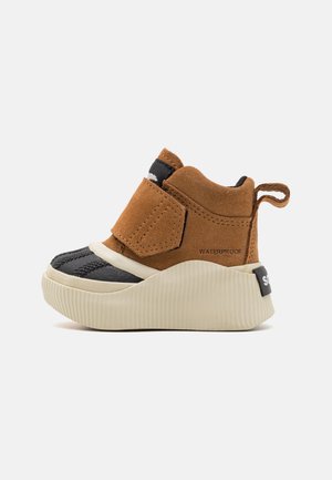 Pruun nubukist king, millel on must kummine varvas, tekstuursed aktsendid, Velcro rihm ja kreemivärvi sooneline tall. Omab "VEESULGUSTAV" sildi.