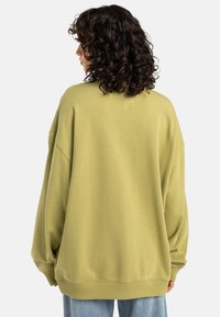 Licht olijfgroene oversized sweatshirt met verlaagde schouders en een licht gestructureerde afwerking, voorzien van een geribde zoom en manchetten.