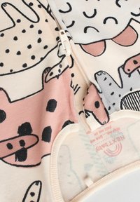 Détente en coton léger avec des imprimés d'animaux de dessin animé en rose, gris et noir sur un fond crème ; comprend une fermeture éclair sur le dessus.