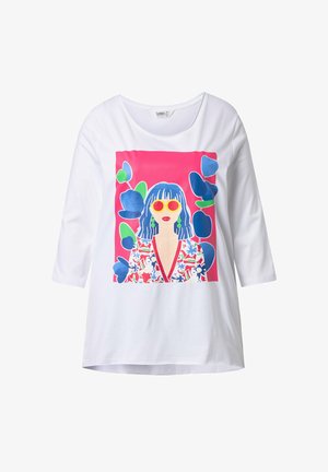 Biała bluzka z długim rękawem z kolorową grafiką przedstawiającą kobietę w żółtych okularach przeciwsłonecznych, zielonych kolczykach, w kwiecistej sukience, z niebieskimi włosami, otoczoną niebieskimi i zielonymi liśćmi.