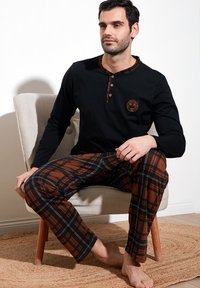 Top negro de manga larga con acentos de cuadros y tapeta de tres botones; pantalones de cuadros marrones. Tela suave y transpirable con un corte holgado.