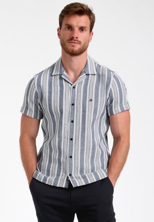 Chemise à manches courtes bleu et blanc, avec des rayures verticales, fermeture à boutons et un col plat. Fabriquée en tissu léger.