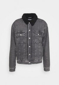 Chaqueta de mezclilla en negro desgastado con un collar de pelo sintético negro, cierres de botones en la parte delantera y dos bolsillos en el pecho. Tejido texturizado con costuras visibles.