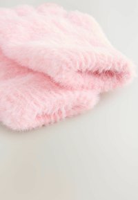 Weiches, gefaltetes hellrosa, flauschiges Strickgewebe mit einer flauschigen Textur auf einem hellen neutralen Hintergrund.