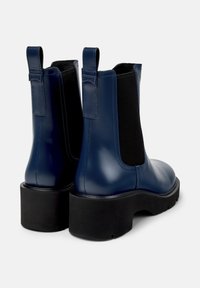Námořnické modré kožené kotníkové boty s elastickými bočními panely a robustní černou gumovou podrážkou, se záhlavím na patě pro snadné obouvání.