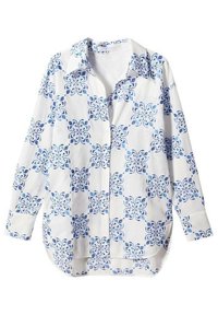 Camisa blanca de botones con un patrón abstracto azul. Mangas largas, cuello clásico y dobladillo curvado. Tejido de algodón ligero.