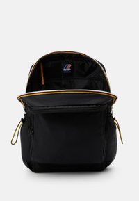 Sac à dos noir avec une ouverture zippée, comprenant une étiquette intérieure, deux poches latérales et un accent multicolore le long du zip.
