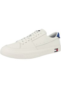 Zapatilla de cuero blanca con suela plana, punta redonda y acentos azules en el talón. Presenta una suela de goma texturizada y costuras decorativas.