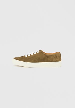 Olivgrüner Wildledersneaker mit weißen Schnürsenkeln, einer abgerundeten Zehenpartie und einer cremefarbenen Gummisohle, mit einem dezenten Logo an der Seite.