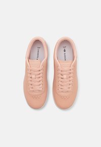Baskets en cuir rose avec une texture lisse, bout arrondi et semelle en caoutchouc blanc. Présente un système de laçage et des détails perforés sur le bout.
