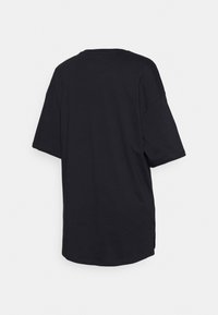 Czarna, oversize koszulka z miękkiej bawełny, z krótkimi rękawami, okrągłym dekoltem oraz dłuższym tylnym hemem z bocznymi rozcięciami.