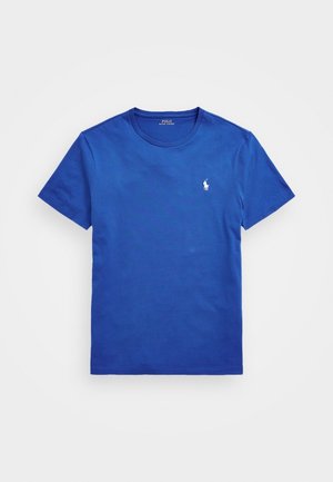 T-shirt bleu à manches courtes avec col rond, petit logo de joueur de polo blanc sur le côté gauche de la poitrine, posé à plat sur fond blanc.