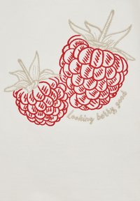 Hímzett minta két piros málna egy fehér szövet háttéren, arany fonallal írt "Looking berry good" felirattal.