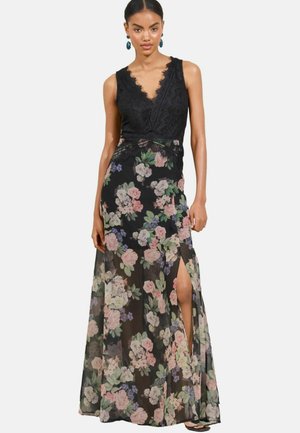 Robe noire en dentelle à corsage, avec une jupe en chiffon floral, présentant un décolleté en V profond, des bords festonnés et une fente sur le côté pour un style supplémentaire.