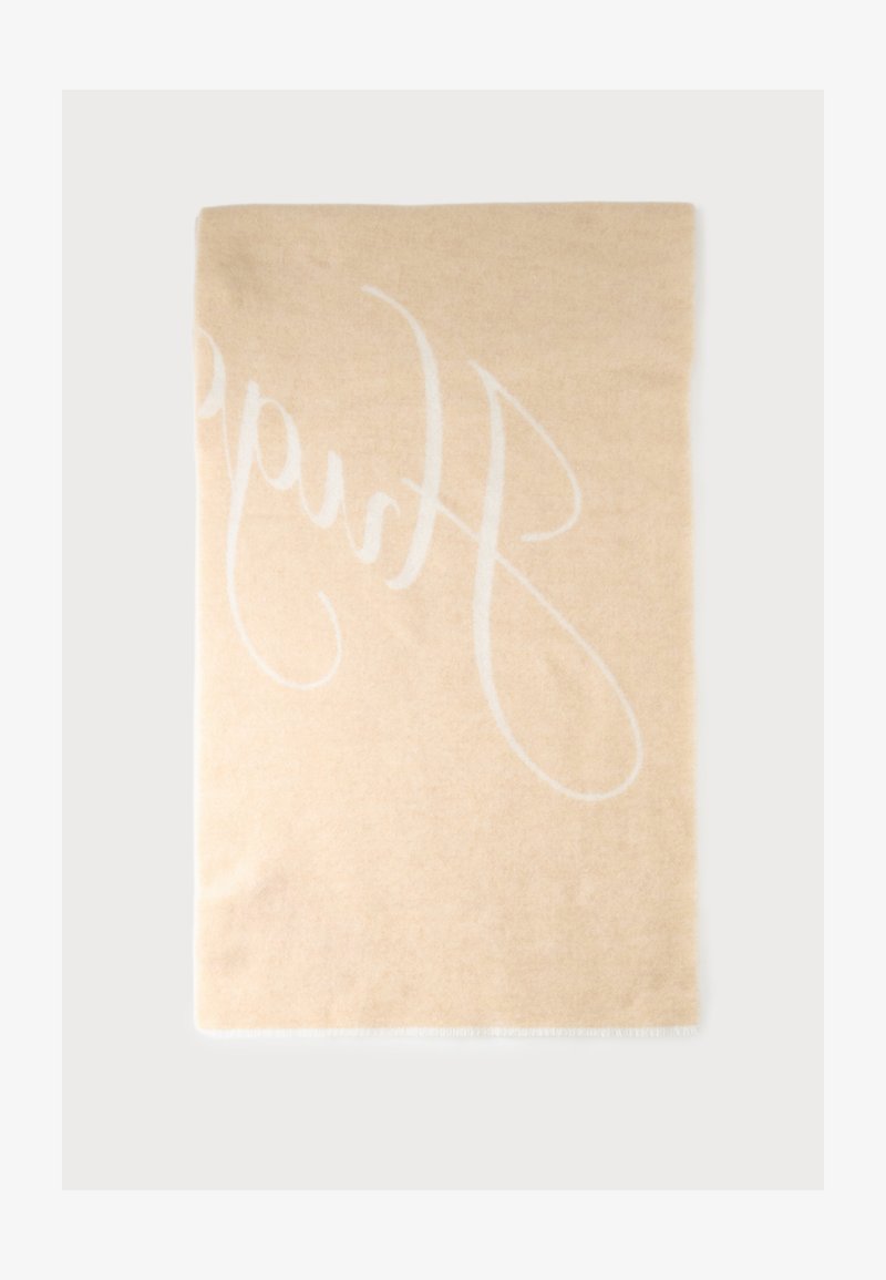 Écharpe rectangulaire beige avec un motif de texte blanc en écriture cursive et bords courts à franges sur un fond uni.
