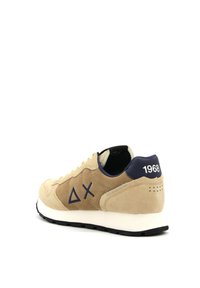 Beige suède sneaker met marineblauwe accenten, voorzien van een witte tussenzool, een opdruklogo en een "1968" detail op de hiel. Klassiek sportief ontwerp.