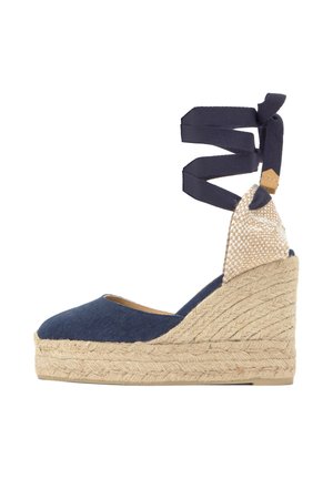 Cuña espadrille azul marino con suela trenzada de yute y cintas para atar al tobillo en tela azul marino.
