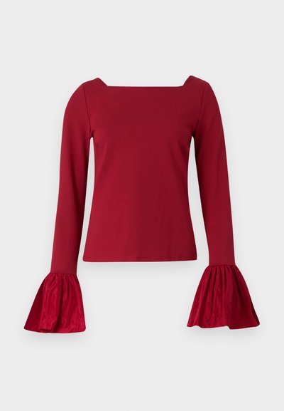 Red long-sleeve top with a square neckline. Features flared, textured sleeves and a smooth body. Made of soft fabric.