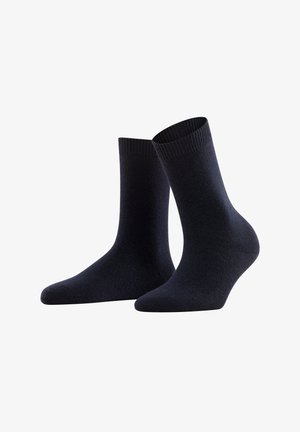 Un paio di calzini neri semplici di lunghezza media con polsini a coste, esposti in posizione verticale su uno sfondo bianco.