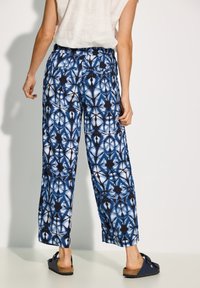 Blue patterned wide-leg pants with a light fabric, featuring an elastic waistband and a geometric print in navy and white.