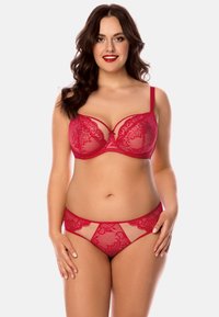 Soutien-gorge en dentelle rouge et culotte assortie avec des panneaux transparents, des motifs floraux complexes et des bretelles ajustables. Tissu doux et texturé.