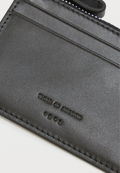 Czarny skórzany portfel na karty z poziomymi slotami na karty, teksturowaną powierzchnią, wytłoczonym logo oraz kontrastowym detalem w postaci przeszycia.