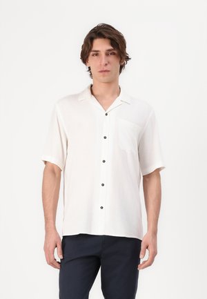 Short-sleeve, white shirt made of lightweight fabric with a collar, featuring a single pocket and black buttons down the front.