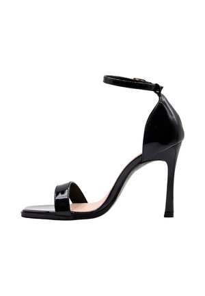 Sandalo nero in pelle verniciata con tacco alto, cinturino alla caviglia, punta aperta e tacco a spillo su sfondo bianco.