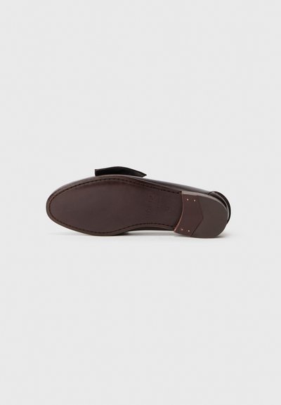 Talpa de pantof din piele maro, cu o textură netedă, formă rotundă și un design minimalist. Caracteristicile notabile includ o curbură subtilă și accente discrete.