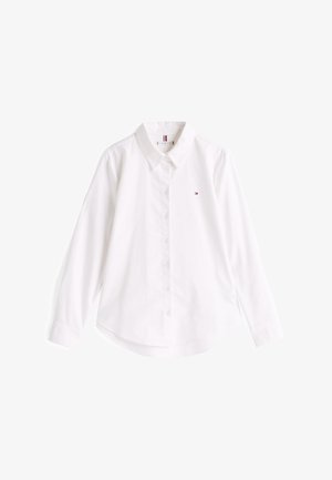 White button-up shirt made of cotton with a classic collar, long sleeves, and a curved hem. Features a small colored logo on the chest.