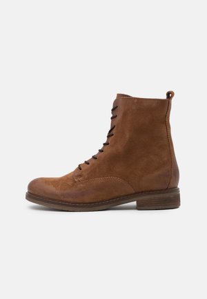 Bottine en cuir marron à lacets, talon bas empilé et languette à l'arrière, vue de profil sur fond blanc.