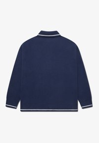 Ναυτικό μπλε πλεκτό πόλο πουλόβερ με γιακά, που διαθέτει λευκές ρίγες στους γιακά και τα μανίκια. Μαλακή υφή, άνετη εφαρμογή.