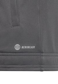 Grå aktivt tøjstof med tekstureret overflade; har et hvidt "AEROREADY" logo og globe ikon, der fremhæver fugttransporterende egenskaber.