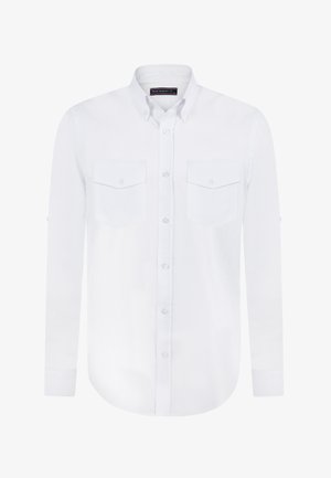 Chemise blanche à boutons, fabriquée dans un tissu lisse, dotée de deux poches à l'avant, de manches longues avec des poignets à bouton et d'un ourlet courbé.