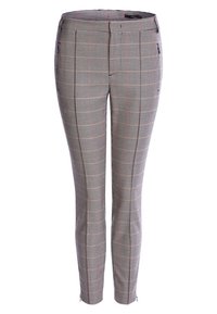 Pantalon à carreaux avec une coupe ajustée, présentant des motifs noirs, blancs et rouges, une texture de tissu lisse et des poches zippées.