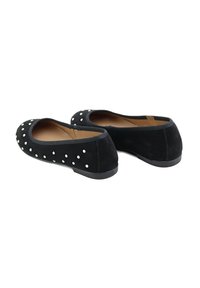Bailarinas de ante negro con puntera redonda y tachuelas plateadas en la parte delantera. Suela de goma plana, interior suave y bordes elásticos.