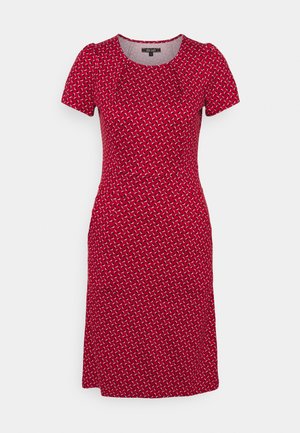 Vestito rosso a maniche corte, lunghezza al ginocchio, con un piccolo motivo geometrico bianco e nero e scollo rotondo.