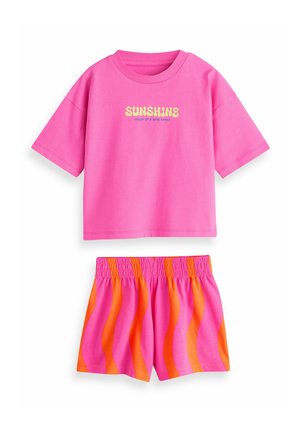 Roosa puuvillane T-särk, millel on kollase värviga trükitud sõna "SUNSHINE", kombineeritud elastse vöökohaga lühikeste pükstega, millel on roosad ja oranžid lainelised triibud.