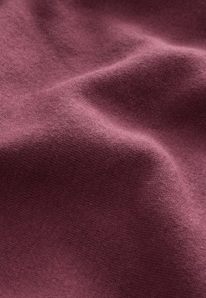 Tekstilstof i vinrød farve med en blød, glat tekstur, let elastisk og med strikkemønster. Ideel til tøj eller polstring.