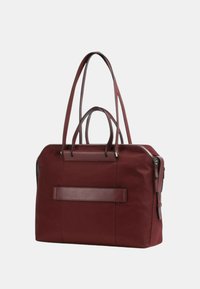 Borsa in tessuto bordeaux con doppi manici superiori e tracolla rimovibile. Presenta un inserto in pelle frontale e un compartimento principale con zip.