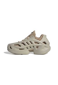 Beige futuristic sneaker with sculpted sole and cut-out ventilation details, featuring lace-up closure and padded collar.