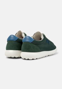 Vihreissä tennareissa on sileä nahkapinta, jossa on samettinen kantapää ja siniset yksityiskohdat. Pohja on valkoinen ja siinä on teksturoitu kuplamuotoilu.