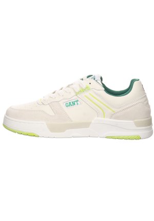 White leather sneakers with green accents, featuring a textured finish, perforations on the toe, and a slim rubber sole with a grip pattern.