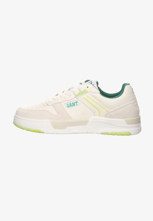 White leather sneakers with green accents, featuring a textured finish, perforations on the toe, and a slim rubber sole with a grip pattern.