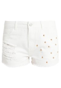 Bílé džíny krátké kalhoty s třepenými okraji, trhlinami na levé straně a zlatými kovovými nýty uspořádanými do vzoru na pravé straně.