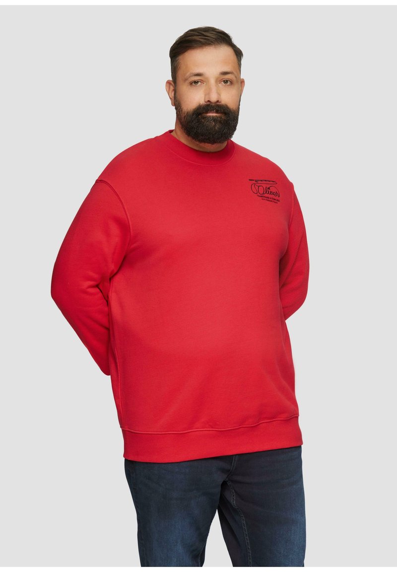 Sweat-shirt rouge avec un col rond, des manches longues et des bords côtelés aux poignets et à l'ourlet. Doté d'un petit logo sur la poitrine et d'une texture lisse.