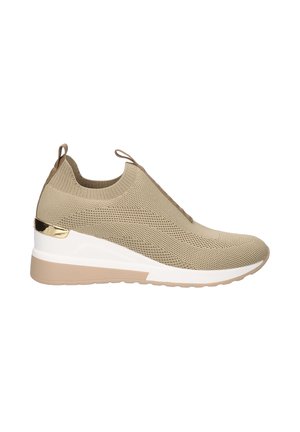 Zapatillas de punto beige con parte superior texturizada, diseño sin cordones y suela en cuña. Presenta un acento metálico en el talón y una tira de agarre.