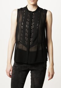 Blusa nera senza maniche con tessuto trasparente, dettagli in pizzo raffinato sul davanti e chiusura a bottoni con scollatura rotonda.