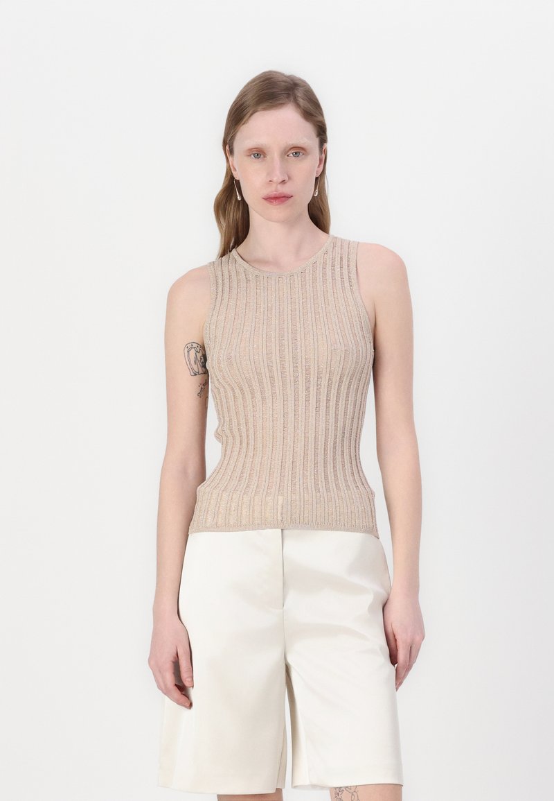 Top bej cu model în dungi, fără mâneci, cu decolteu rotund. Realizat dintr-un material texturat, cu un design ajustat, asortat cu pantaloni scurți albi cu structură.