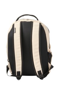 Mochila bicolor con un esquema de colores crema y negro, que presenta un acolchado de malla en la parte posterior y correas ajustables para mayor comodidad.